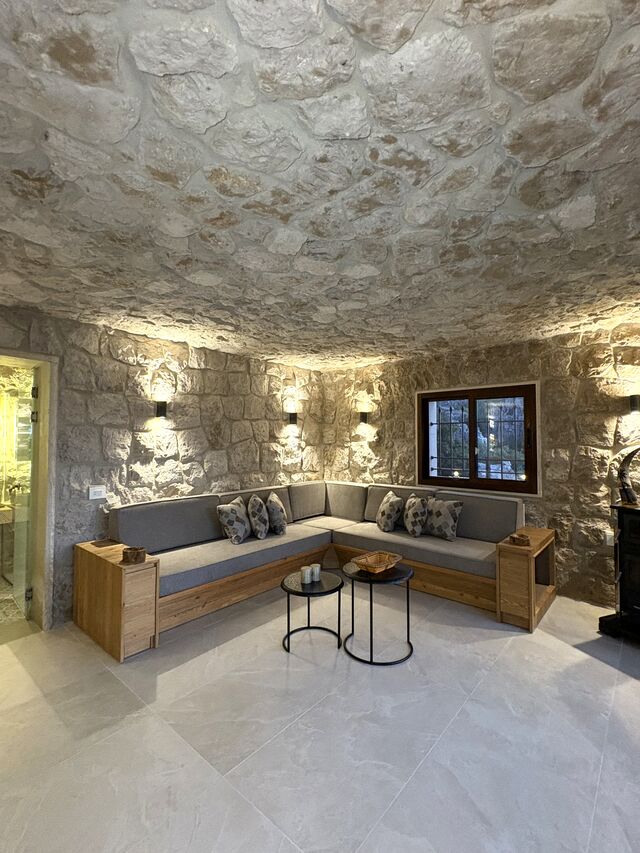 La Grande's corner sofa under the vaulted stone ceiling, with a low table and a window onto the terrace.