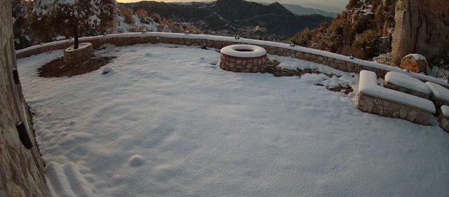 Snow lying across the terrace and stone wall in January.