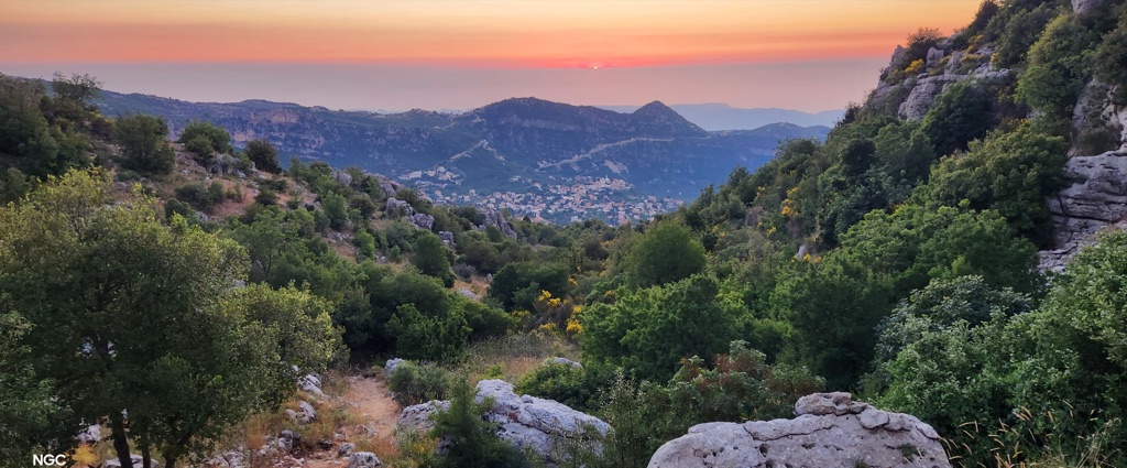 The marked trail leading down from the ridge toward the Douma valley at sunset.